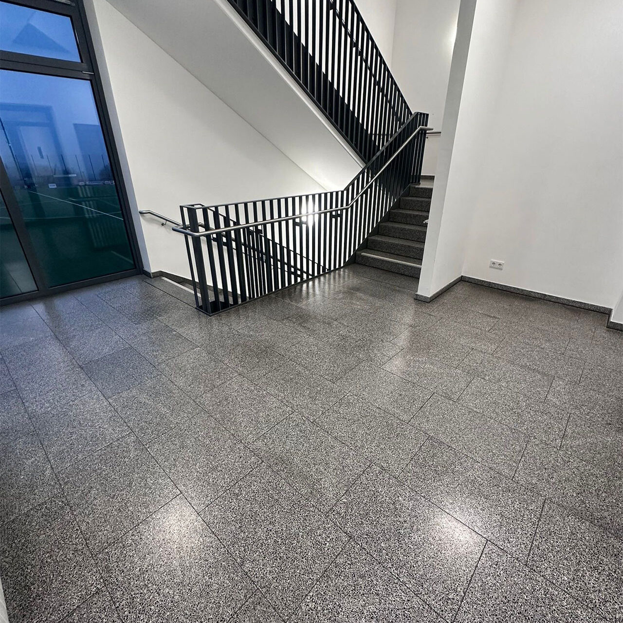 Sie sehen eine frisch gereinigte Treppe einer modernen Schule.