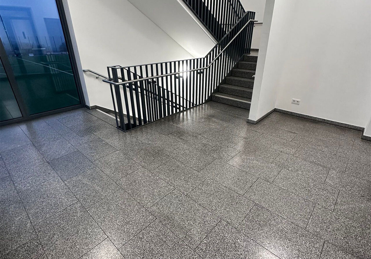 Sie sehen eine frisch gereinigte Treppe einer modernen Schule.